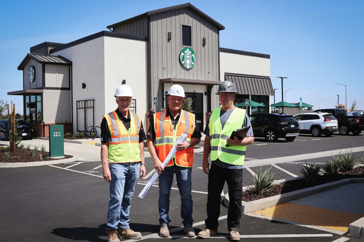 Three men from Cal Gold Construction standing in front of a Starbucks project.